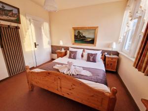 a bedroom with a wooden bed with a flower on it at Hotel Elisabeth Ilse in Braunlage