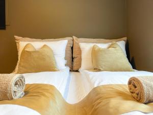 a large bed with white sheets and yellow pillows at For Groups & Families - FREE Parking & Near Attractions in Tromsø