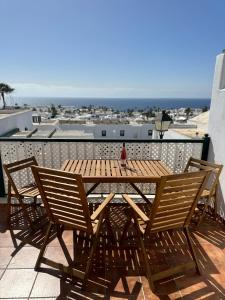 drewniany stół i krzesła na balkonie z widokiem na ocean w obiekcie Casa Josephine Lanzarote, spectacular sea views & FREE WiFi w Puerto del Carmen