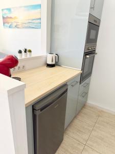W kuchni znajduje się drewniany blat i lodówka. w obiekcie Casa Josephine Lanzarote, spectacular sea views & FREE WiFi w Puerto del Carmen