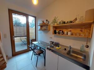 uma cozinha com um lavatório, uma mesa e uma janela em Le Gîte du Herdal em Profondeville
