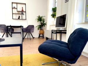 a living room with a blue chair and a table at Hip & Minimalist meets Historical Old Town in Pirna