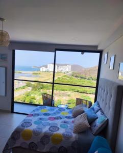 een slaapkamer met een bed en uitzicht op de oceaan bij APARTASUITE LUCIA SUN SET in Santa Marta