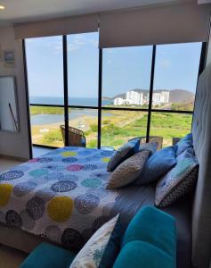 een slaapkamer met een bed en uitzicht op de oceaan bij APARTASUITE LUCIA SUN SET in Santa Marta +40 foto's