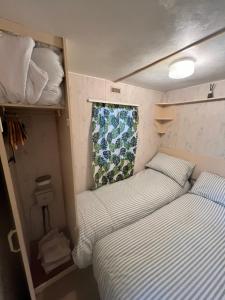 a bedroom with two beds in a trailer at City Caravan, 5 mins from Cardiff city centre, Dog Friendly and perfect weekend Getaway in Cardiff