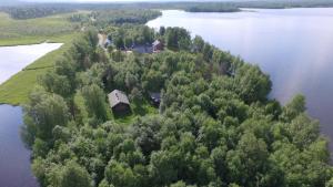 una isla en el agua con una casa en ella en Lakeside Holiday Cottage near Ivalo - Minna-Carita's, en Ivalo