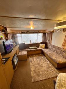 a living room with a couch and a television at City Caravan, 5 mins from Cardiff city centre, Dog Friendly and perfect weekend Getaway in Cardiff