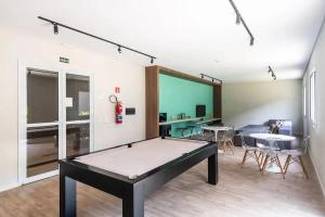 サンパウロにあるCompleto, moderno e bem localizado na Rua do Metrô Brás SPの卓球台とダイニングルームが備わる客室です。