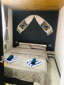 a bedroom with a bed with towels on it at Cabana La Batranu in Borşa