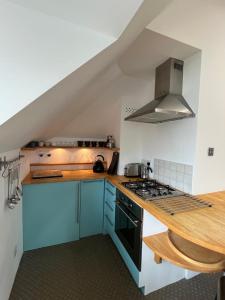a kitchen with blue cabinets and a stove top oven at The Loft in London