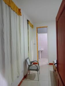 a chair sitting in a room with a bathroom at Seven Seven B&B in Arusha