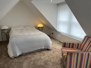 ein Schlafzimmer mit einem weißen Bett und einem Stuhl in der Unterkunft The Loft in London