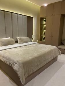 a bedroom with a large bed and a closet at شقة فاخرة بمدخل طراز سلماني in Riyadh
