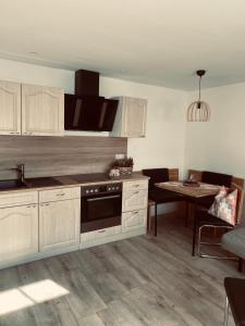 a kitchen with white cabinets and a table with a dining room at Ferienwohnung Leadro in Kurort Oberwiesenthal