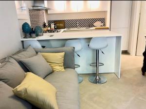 ein Wohnzimmer mit einem Sofa und einer Küche in der Unterkunft CASA MANDO with Terrace and Jacuzzi in Taormina