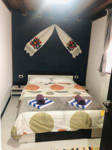 a bedroom with a bed with two hats on it at Cabana La Batranu in Borşa