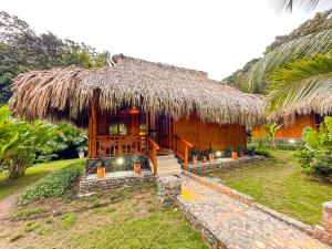 ein Haus mit einem Strohdach und einer Außentreppe in der Unterkunft Ecohabs Bamboo Parque Tayrona - Dentro del PNN Tayrona in El Zaino