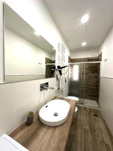 W łazience znajduje się biała umywalka i prysznic. w obiekcie Dimora Centrale Home w mieście Napoli