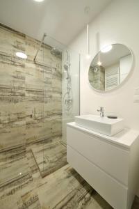 ein weißes Badezimmer mit einem Waschbecken und einem Spiegel in der Unterkunft Apartament Wrocław in Breslau