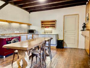 a large kitchen with a wooden table and chairs at chez Fred in Saint-Rambert-en-Bugey +2 photos