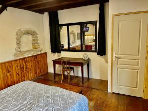 een slaapkamer met een bed, een tafel en een raam bij chez Fred in Saint-Rambert-en-Bugey