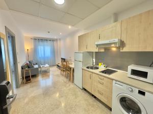 uma cozinha com máquina de lavar e secar roupa num quarto em ApartSur® em Bormujos
