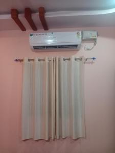 a room with a heater and a window curtain at Puneetha home stay hampi in Hampi