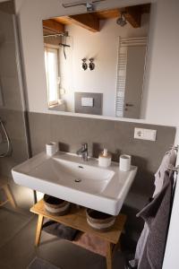 un bagno con un lavandino bianco e uno specchio di Ferienwohnung Heller a Gengenbach Altre 30 foto