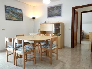 uma sala de jantar com uma mesa de madeira e cadeiras em Attico mansardato luminoso em Orsogna