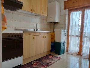 uma cozinha com um lavatório e um fogão em Attico mansardato luminoso em Orsogna