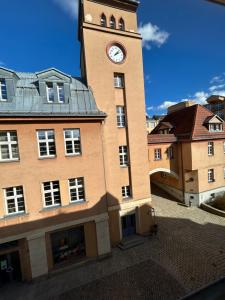 a large building with a clock tower on it at Stadtquartier am Rathaus in Lichtenstein-Callnberg