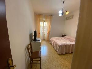 a bedroom with a bed and a desk with a television at Appartamento sul lungomare - Ladispoli in Ladispoli