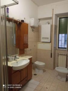 ein Bad mit einem Waschbecken und einem WC in der Unterkunft Appartamento sul lungomare - Ladispoli in Ladispoli