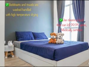 two teddy bears sitting on a bed in a bedroom at Penang Straits Garden Condominium Georgetown in George Town