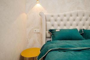 1 dormitorio con cama verde y cabecero blanco en Decebal Apartment, en Chişinău