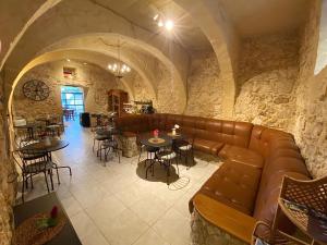 un restaurant avec un canapé en cuir, des tables et des chaises dans l'établissement SUNRISE VIEW VILLA, à Qala