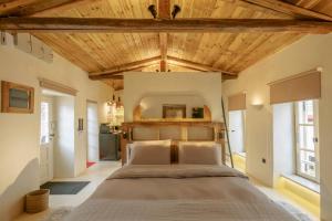 a bedroom with a large bed with a wooden ceiling at SUITE HOUSE THISSION in Athens