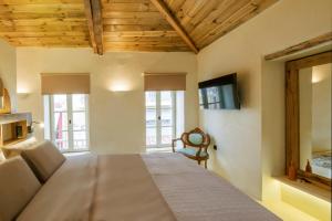 a large bed in a room with wooden ceilings at SUITE HOUSE THISSION in Athens