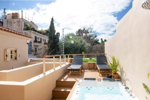 Un balcón con jacuzzi y dos sillas en SUITE HOUSE THISSION, en Atenas