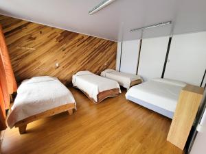 two beds in a room with wooden floors at Cabinas Selva Verde in Monteverde Costa Rica