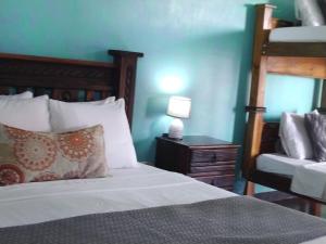 1 dormitorio con cama y mesita de noche con lámpara en Lajuela BnB & Hostel, en Alajuela