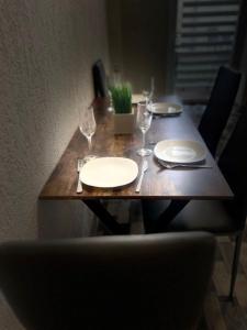 uma mesa de madeira com pratos e copos de vinho em Am Bahnhof em Zwickau