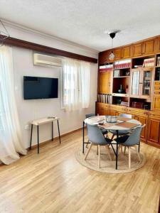 Central House in Plaka في أثينا: غرفة طعام مع طاولة وكراسي وتلفزيون