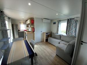 un petit salon avec un canapé et une table dans l'établissement MOBIL HOME CAMPING LES VIVIERS 4 ETOILEs, à Lège-Cap-Ferret
