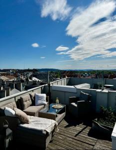 Frogner Park Penthouse Terrace في أوسلو: شرفة مع كنب وطاولة على السطح