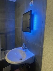 ein Bad mit einem Waschbecken und einem Wandspiegel in der Unterkunft Zum Bahnhof in Zwickau