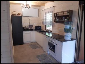 a kitchen with a black refrigerator and a counter top at Domek letniskowy Ania in Pasym