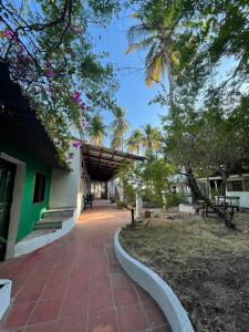 una pasarela frente a un edificio con árboles en Sugarloaf Beach House & Surf Lodge, en El Cuco