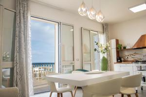 a kitchen and dining room with a white table and chairs at La Villa di Nonna Pina in Balestrate +53 photos