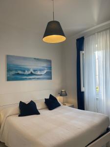 a bedroom with a large white bed with blue pillows at Case Vacanze Ganimede in Sperlonga